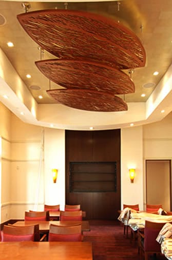 A room with chairs and a large wooden ceiling.