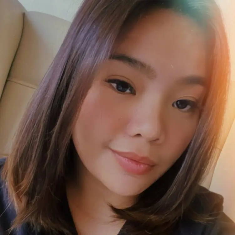 A close-up of a young woman with shoulder-length hair and warm lighting.