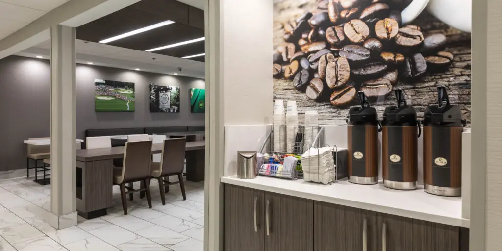 Coffee station with chairs and mirrors in the background.